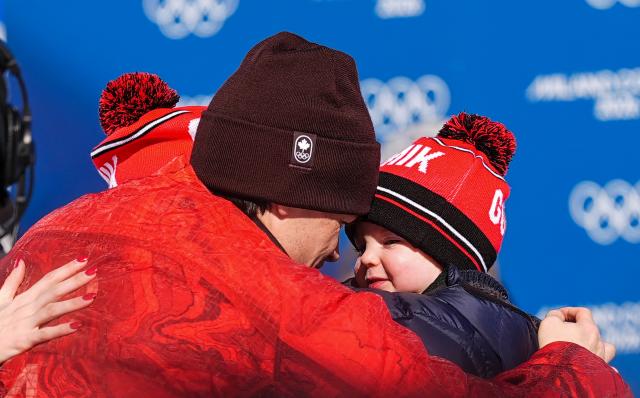 (260215) -- LIVIGNO, Feb. 15, 2026 (Xinhua) -- Gold medalist Mikael Kingsbury of Canada hugs his families after the awarding ceremony for the freestyle skiing men's dual moguls at the Milan-Cortina 2026 Olympic Winter Games in Livigno, Italy, Feb. 15, 2026. (Xinhua/Wu Huiwo)