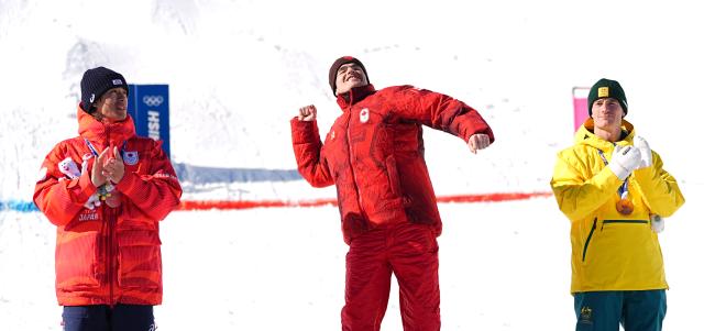 (260215) -- LIVIGNO, Feb. 15, 2026 (Xinhua) -- Gold medalist Mikael Kingsbury (C) of Canada, silver medalist Horishima Ikuma (L) of Japan and bronze medalist Matt Graham of Australia react during the awarding ceremony for the freestyle skiing men's dual moguls at the Milan-Cortina 2026 Olympic Winter Games in Livigno, Italy, Feb. 15, 2026. (Xinhua/Wu Huiwo)