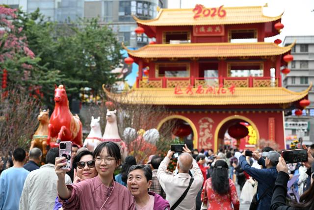 (260215) -- GUANGZHOU, Feb. 15, 2026 (Xinhua) -- People pose for a selfie at a flower market in Yuexiu District, Guangzhou, south China's Guangdong Province, Feb. 15, 2026. China is alive with vibrant celebrations with the Spring Festival just around the corner. (Xinhua/Deng Hua)