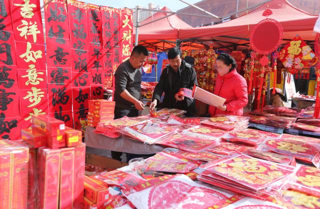 (260215) -- BEIJING, Feb. 15, 2026 (Xinhua) -- People shop for Chinese New Year decorations at a market in Dingxi City, northwest China's Gansu Province, Feb. 14, 2026. China is alive with vibrant celebrations with the Spring Festival just around the corner. (Photo by Wang Kexian/Xinhua)