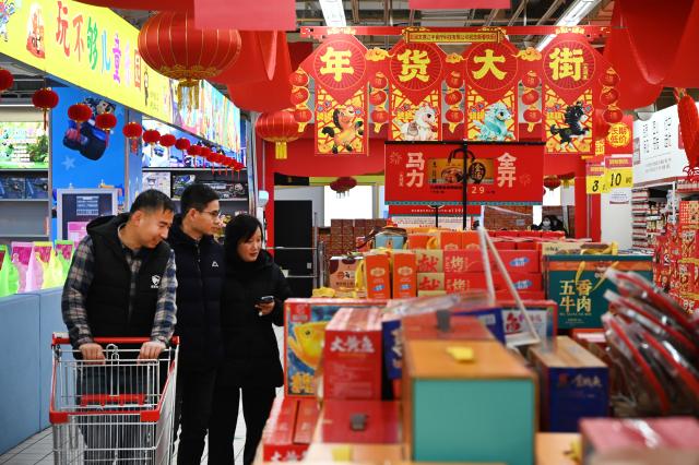 (260215) -- BEIJING, Feb. 15, 2026 (Xinhua) -- People shop for goods needed for the Chinese New Year celebrations at a market in Kaifeng, central China's Henan Province, Feb. 15, 2026. China is alive with vibrant celebrations with the Spring Festival just around the corner. (Photo by Li Junsheng/Xinhua)
