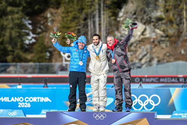 (260215) -- ANTERSELVA, Feb. 15, 2026 (Xinhua) -- Gold medalist Martin Fourcade (C) of France, silver medalist Pavol Hurajt (L) of Slovakia and bronze medalist Christoph Sumann of Austria for the biathlon men's 15km mass start from the 2010 Vancouver Winter Olympics pose for photos during a reallocation medals ceremony at the 2026 Winter Olympics in Anterselva, Italy, Feb. 15, 2026. (Xinhua/Jiang Han)