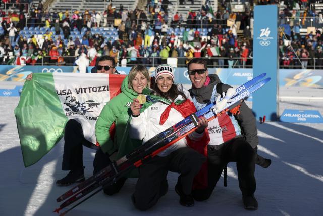 (260215) -- ANTERSELVA), Feb. 15, 2026 (Xinhua) -- Lisa Vittozzi (2nd R) of Italy poses for photos with her family after the awarding ceremony of the biathlon women's 10km pursuit at the 2026 Milan-Cortina Winter Olympics in Anterselva, Italy, Feb. 15, 2026. (Xinhua/Zhang Tao)