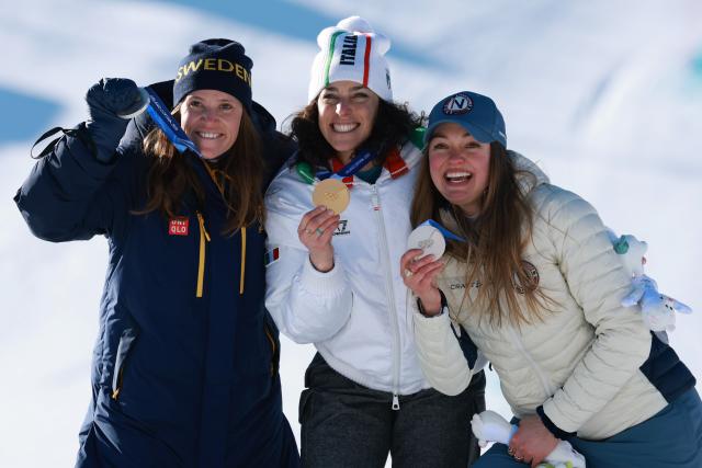 (260215) -- CORTINA D'AMPEZZO, Feb. 15, 2026 (Xinhua) -- Gold medalist Federica Brignone (C) of Italy, and silver medalist Sara Hector (L) of Sweden and Thea Louise Stjernesund of Norway pose for photos during the awarding ceremony of the alpine skiing women's giant slalom at the Milan-Cortina 2026 Olympic Winter Games in Cortina, Italy, Feb. 15, 2026. (Xinhua/Zhang Chenlin)