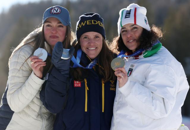 (260215) -- CORTINA D'AMPEZZO, Feb. 15, 2026 (Xinhua) -- Gold medalist Federica Brignone (R) of Italy, and silver medalist Sara Hector (C) of Sweden and Thea Louise Stjernesund of Norway pose for photos during the awarding ceremony of the alpine skiing women's giant slalom at the Milan-Cortina 2026 Olympic Winter Games in Cortina, Italy, Feb. 15, 2026. (Xinhua/Zhang Chenlin)