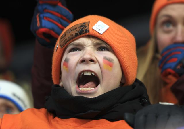 (260215) -- CORTINA D'AMPEZZO, Feb. 15, 2026 (Xinhua) -- A spectator cheers for German athletes during the skeleton mixed team competition at the Milan-Cortina 2026 Olympic Winter Games in Cortina, Italy, Feb. 15, 2026. (Xinhua/Ding Xu)