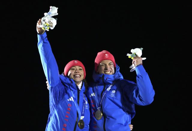 (260215) -- CORTINA D'AMPEZZO, Feb. 15, 2026 (Xinhua) -- Gold medalists Tabitha Stoecker (L)/Matt Weston of Britain celebrate during the awarding ceremony of the skeleton mixed team competition at the Milan-Cortina 2026 Olympic Winter Games in Cortina, Italy, Feb. 15, 2026. (Xinhua/Li Gang)