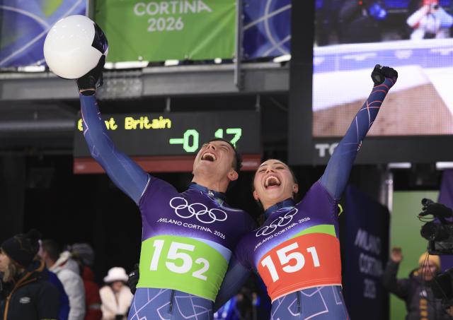 (260215) -- CORTINA D'AMPEZZO, Feb. 15, 2026 (Xinhua) -- Tabitha Stoecker (R)/Matt Weston of Britain celebrate after the skeleton mixed team competition at the Milan-Cortina 2026 Olympic Winter Games in Cortina, Italy, Feb. 15, 2026. (Xinhua/Ding Xu)