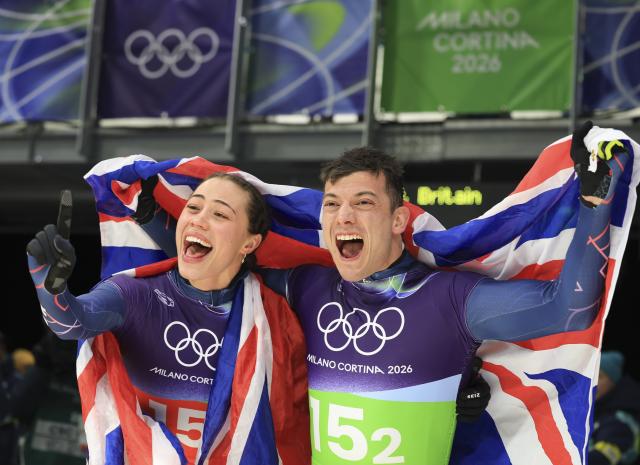 (260215) -- CORTINA D'AMPEZZO, Feb. 15, 2026 (Xinhua) -- Tabitha Stoecker (L)/Matt Weston of Britain celebrate after the skeleton mixed team competition at the Milan-Cortina 2026 Olympic Winter Games in Cortina, Italy, Feb. 15, 2026. (Xinhua/Ding Xu)
