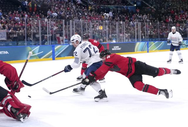 (260215) -- MILAN, Feb. 15, 2026 (Xinhua) -- Jordann Perret (4th R) of France vies with Cale Makar (2nd R) of Canada during the ice hockey men's preliminary round group A match between Canada and France at the Milan-Cortina 2026 Olympic Winter Games in Milan, Italy, Feb. 15, 2026. (Xinhua/Tao Xiyi)