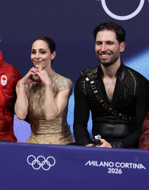 (260216) -- MILAN, Feb. 16, 2026 (Xinhua) -- Deanna Stellato-Dudek and Maxime Deschamps of Canada wait for the score after their performance during the figure skating pair skating short program match at the Milan-Cortina 2026 Olympic Winter Games in Milan, Italy, Feb. 15, 2026. (Xinhua/Chen Yichen)