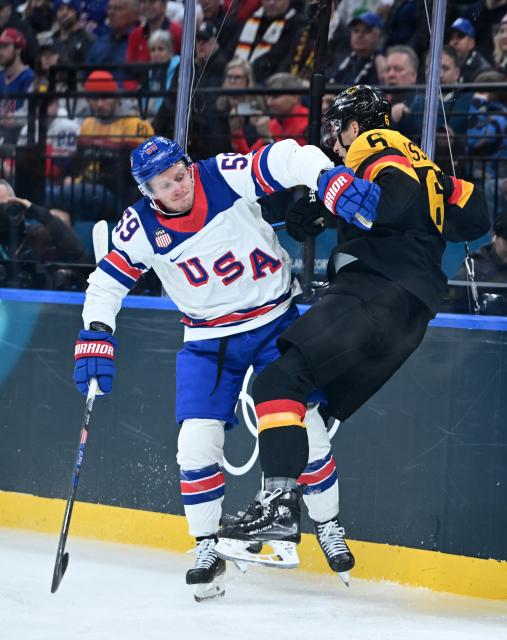 (260216) -- MILAN, Feb. 16, 2026 (Xinhua) -- Jake Guentzel (L) of the United States and Kai Wissmann of Germany clash during the ice hockey men's preliminary round group C match between the United States and Germany at the Milan-Cortina 2026 Olympic Winter Games in Milan, Italy, Feb. 15, 2026. (Xinhua/Zhang Haofu)