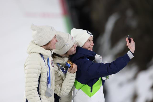 (260216) -- PREDAZZO, Feb. 16, 2026 (Xinhua) -- Silver medallist Norway's Eirin Maria Kvandal, gold medallist Norway's Anna Odine Stroem and bronze medallist Slovenia's Nika Prevc (L to R) pose a selfie on the podium for of ski jumping women's large hill individual event at the Milan-Cortina 2026 Olympic Winter Games in Predazzo, Italy, Feb. 15, 2026. (Xinhua/Huang Wei)