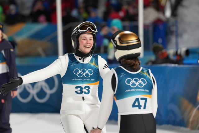 (260216) -- PREDAZZO, Feb. 16, 2026 (Xinhua) -- Norway's Silje Opseth (L) congratulates Norway's Anna Odine Stroem after Stroem won gold in the final round of ski jumping women's large hill individual event at the Milan-Cortina 2026 Olympic Winter Games in Predazzo, Italy, Feb. 15, 2026. (Xinhua/Meng Yongmin)