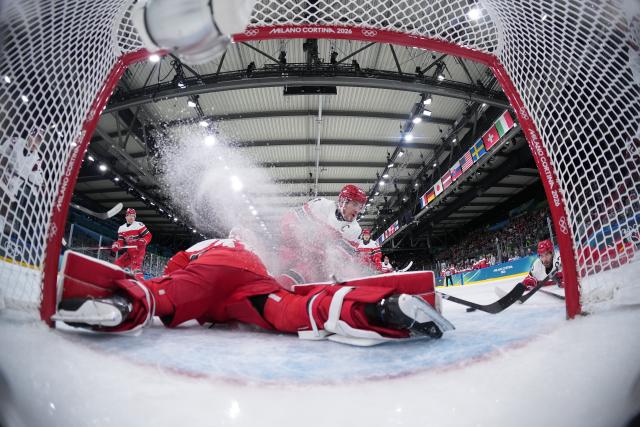 (260216) -- MILAN, Feb. 16, 2026 (Xinhua) -- Goalkeeper Frederik Anderson (bottom) of Denmark makes a save during the ice hockey men's preliminary round group C match between Denmark and Latvia at the Milan-Cortina 2026 Olympic Winter Games in Milan, Italy, Feb. 15, 2026. (Xinhua/Wang Kaiyan)