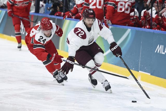 (260216) -- MILAN, Feb. 16, 2026 (Xinhua) -- Janis Jaks (R) of Latvia vies with Nikolaj Ehlers of Denmark during the ice hockey men's preliminary round group C match between Denmark and Latvia at the Milan-Cortina 2026 Olympic Winter Games in Milan, Italy, Feb. 15, 2026. (Xinhua/Wang Kaiyan)
