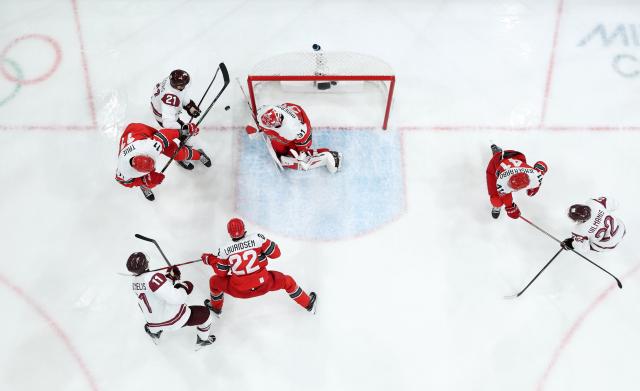 (260216) -- MILAN, Feb. 16, 2026 (Xinhua) -- Alexander True (L, top) of Denmark vies with Rudolfs Balcers (C, top) of Latvia during the ice hockey men's preliminary round group C match between Denmark and Latvia at the Milan-Cortina 2026 Olympic Winter Games in Milan, Italy, Feb. 15, 2026. (Xinhua/Wang Kaiyan)