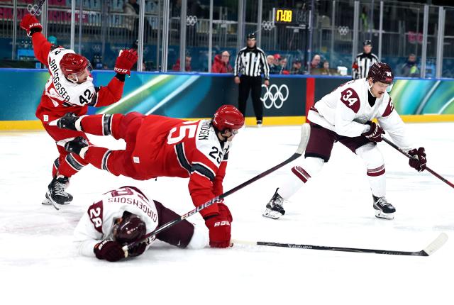 (260216) -- MILAN, Feb. 16, 2026 (Xinhua) -- Oliver Lauridsen (C) of Denmark and Zemgus Girgensons (bottom) of Latvia fall during the ice hockey men's preliminary round group C match between Denmark and Latvia at the Milan-Cortina 2026 Olympic Winter Games in Milan, Italy, Feb. 15, 2026. (Xinhua/Wang Kaiyan)