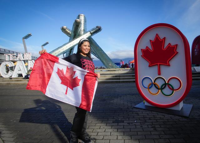 (260216) -- VANCOUVER, Feb. 16, 2026 (Xinhua) -- A woman poses for photos in front of a Team Canada signage during the Team Canada Fanfest in Vancouver, Canada, on Feb. 15, 2026. The event is part of a nationwide FanFest series planned for Canadian cities during 2026 Milan-Cortina Winter Olympics. (Photo by Liang Sen/Xinhua)