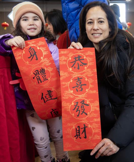 (260216) -- TORONTO, Feb. 16, 2026 (Xinhua) -- A woman and her child display Chinese calligraphy works in celebration of Chinese New Year at the Chinese Cultural Center of Greater Toronto in Toronto, Canada, Feb. 15, 2026. (Photo by Zou Zheng/Xinhua)