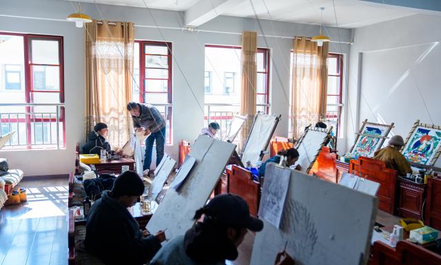 (260216) -- LHASA, Feb. 16, 2026 (Xinhua) -- Norbu Sidar instructs his apprentice at the Xizang Academy of Thangka in Lhasa, southwest China's Xizang Autonomous Region, Feb. 10, 2026. On the afternoon of Feb. 10, sunlight streamed through the windows of the Xizang Academy of Thangka, illuminating an unfinished thangka painting. Norbu Sidar stood beside a young apprentice. He reached out, gently placing his finger on a specific spot on the canvas, and quietly guided the apprentice on the direction of the lines. 
   Thangka, renowned for its meticulous composition, vibrant colors, and profound cultural connotations, was listed among the first batch of China's national intangible cultural heritages in 2006. Recording Tibetan history, culture, medicine, astronomy, and other knowledge, it carries the spiritual beliefs and aesthetic wisdom of people in Xizang throughout the times.
   Norbu Sidar is a national-level inheritor of the Tibetan thangka. As a child, he learned thangka painting techniques from his grandfather. He recalled, "Time was most precious when I was little. I could only learn to paint thangka in my spare time after helping the family with farm and livestock work." From 2005 to 2015, he spent ten years as a restoration expert undertaking the mural restoration project at the Potala Palace. In 2016, he donated the 18 thangka works he had copied at the Potala Palace over the decade to the Palace. "These ten years have been the most meaningful part of my life," he recalled.
   In 1992, Norbu Sidar began taking on students. Ten years later, he led the founding of the Xizang Academy of Thangka. Today, as a master's supervisor at the School of Arts of Xizang University, he guides graduate students in studying the history of thangka and encourages young people to experiment with new forms of expression. To date, over 400 students are, like him, contributing to the development of Tibetan thangka art.
    After being elected as a member of the National Committee of the Chinese People's Political Consultative Conference, Norbu Sidar felt he had the responsibility to do more to make thangka, the artistic treasure in Xizang, recognized, supported and passed down through generations. (Xinhua/Tenzin Nyida)