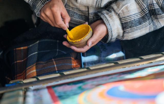 (260216) -- LHASA, Feb. 16, 2026 (Xinhua) -- An apprentice of Norbu Sidar prepares pigment at the Xizang Academy of Thangka in Lhasa, southwest China's Xizang Autonomous Region, Feb. 10, 2026. On the afternoon of Feb. 10, sunlight streamed through the windows of the Xizang Academy of Thangka, illuminating an unfinished thangka painting. Norbu Sidar stood beside a young apprentice. He reached out, gently placing his finger on a specific spot on the canvas, and quietly guided the apprentice on the direction of the lines. 
   Thangka, renowned for its meticulous composition, vibrant colors, and profound cultural connotations, was listed among the first batch of China's national intangible cultural heritages in 2006. Recording Tibetan history, culture, medicine, astronomy, and other knowledge, it carries the spiritual beliefs and aesthetic wisdom of people in Xizang throughout the times.
   Norbu Sidar is a national-level inheritor of the Tibetan thangka. As a child, he learned thangka painting techniques from his grandfather. He recalled, "Time was most precious when I was little. I could only learn to paint thangka in my spare time after helping the family with farm and livestock work." From 2005 to 2015, he spent ten years as a restoration expert undertaking the mural restoration project at the Potala Palace. In 2016, he donated the 18 thangka works he had copied at the Potala Palace over the decade to the Palace. "These ten years have been the most meaningful part of my life," he recalled.
   In 1992, Norbu Sidar began taking on students. Ten years later, he led the founding of the Xizang Academy of Thangka. Today, as a master's supervisor at the School of Arts of Xizang University, he guides graduate students in studying the history of thangka and encourages young people to experiment with new forms of expression. To date, over 400 students are, like him, contributing to the development of Tibetan thangka art.
    After being elected as a member of the National Committee of the Chinese People's Political Consultative Conference, Norbu Sidar felt he had the responsibility to do more to make thangka, the artistic treasure in Xizang, recognized, supported and passed down through generations. (Xinhua/Tenzin Nyida)