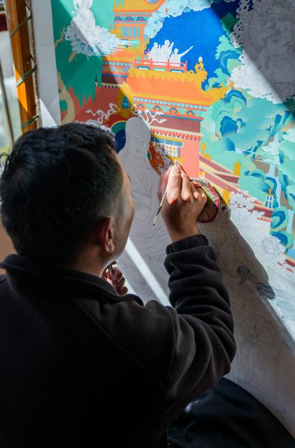 (260216) -- LHASA, Feb. 16, 2026 (Xinhua) -- An apprentice of Norbu Sidar draws a thangka at the Xizang Academy of Thangka in Lhasa, southwest China's Xizang Autonomous Region, Feb. 10, 2026. On the afternoon of Feb. 10, sunlight streamed through the windows of the Xizang Academy of Thangka, illuminating an unfinished thangka painting. Norbu Sidar stood beside a young apprentice. He reached out, gently placing his finger on a specific spot on the canvas, and quietly guided the apprentice on the direction of the lines. 
   Thangka, renowned for its meticulous composition, vibrant colors, and profound cultural connotations, was listed among the first batch of China's national intangible cultural heritages in 2006. Recording Tibetan history, culture, medicine, astronomy, and other knowledge, it carries the spiritual beliefs and aesthetic wisdom of people in Xizang throughout the times.
   Norbu Sidar is a national-level inheritor of the Tibetan thangka. As a child, he learned thangka painting techniques from his grandfather. He recalled, "Time was most precious when I was little. I could only learn to paint thangka in my spare time after helping the family with farm and livestock work." From 2005 to 2015, he spent ten years as a restoration expert undertaking the mural restoration project at the Potala Palace. In 2016, he donated the 18 thangka works he had copied at the Potala Palace over the decade to the Palace. "These ten years have been the most meaningful part of my life," he recalled.
   In 1992, Norbu Sidar began taking on students. Ten years later, he led the founding of the Xizang Academy of Thangka. Today, as a master's supervisor at the School of Arts of Xizang University, he guides graduate students in studying the history of thangka and encourages young people to experiment with new forms of expression. To date, over 400 students are, like him, contributing to the development of Tibetan thangka art.
    After being elected as a member of the National Committee of the Chinese People's Political Consultative Conference, Norbu Sidar felt he had the responsibility to do more to make thangka, the artistic treasure in Xizang, recognized, supported and passed down through generations. (Xinhua/Tenzin Nyida)