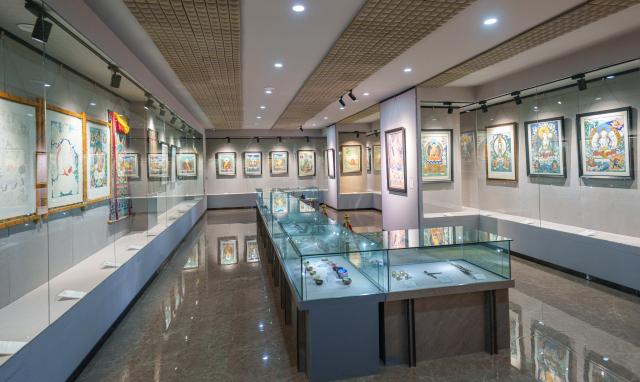 (260216) -- LHASA, Feb. 16, 2026 (Xinhua) -- Thangka works are displayed at the exhibiton hall of the Xizang Academy of Thangka in Lhasa, southwest China's Xizang Autonomous Region, Feb. 10, 2026. On the afternoon of Feb. 10, sunlight streamed through the windows of the Xizang Academy of Thangka, illuminating an unfinished thangka painting. Norbu Sidar stood beside a young apprentice. He reached out, gently placing his finger on a specific spot on the canvas, and quietly guided the apprentice on the direction of the lines. 
   Thangka, renowned for its meticulous composition, vibrant colors, and profound cultural connotations, was listed among the first batch of China's national intangible cultural heritages in 2006. Recording Tibetan history, culture, medicine, astronomy, and other knowledge, it carries the spiritual beliefs and aesthetic wisdom of people in Xizang throughout the times.
   Norbu Sidar is a national-level inheritor of the Tibetan thangka. As a child, he learned thangka painting techniques from his grandfather. He recalled, "Time was most precious when I was little. I could only learn to paint thangka in my spare time after helping the family with farm and livestock work." From 2005 to 2015, he spent ten years as a restoration expert undertaking the mural restoration project at the Potala Palace. In 2016, he donated the 18 thangka works he had copied at the Potala Palace over the decade to the Palace. "These ten years have been the most meaningful part of my life," he recalled.
   In 1992, Norbu Sidar began taking on students. Ten years later, he led the founding of the Xizang Academy of Thangka. Today, as a master's supervisor at the School of Arts of Xizang University, he guides graduate students in studying the history of thangka and encourages young people to experiment with new forms of expression. To date, over 400 students are, like him, contributing to the development of Tibetan thangka art.
    After being elected as a member of the National Committee of the Chinese People's Political Consultative Conference, Norbu Sidar felt he had the responsibility to do more to make thangka, the artistic treasure in Xizang, recognized, supported and passed down through generations. (Xinhua/Tenzin Nyida)