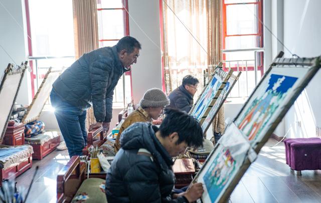 (260216) -- LHASA, Feb. 16, 2026 (Xinhua) -- Norbu Sidar instructs his apprentice at the Xizang Academy of Thangka in Lhasa, southwest China's Xizang Autonomous Region, Feb. 10, 2026. On the afternoon of Feb. 10, sunlight streamed through the windows of the Xizang Academy of Thangka, illuminating an unfinished thangka painting. Norbu Sidar stood beside a young apprentice. He reached out, gently placing his finger on a specific spot on the canvas, and quietly guided the apprentice on the direction of the lines. 
   Thangka, renowned for its meticulous composition, vibrant colors, and profound cultural connotations, was listed among the first batch of China's national intangible cultural heritages in 2006. Recording Tibetan history, culture, medicine, astronomy, and other knowledge, it carries the spiritual beliefs and aesthetic wisdom of people in Xizang throughout the times.
   Norbu Sidar is a national-level inheritor of the Tibetan thangka. As a child, he learned thangka painting techniques from his grandfather. He recalled, "Time was most precious when I was little. I could only learn to paint thangka in my spare time after helping the family with farm and livestock work." From 2005 to 2015, he spent ten years as a restoration expert undertaking the mural restoration project at the Potala Palace. In 2016, he donated the 18 thangka works he had copied at the Potala Palace over the decade to the Palace. "These ten years have been the most meaningful part of my life," he recalled.
   In 1992, Norbu Sidar began taking on students. Ten years later, he led the founding of the Xizang Academy of Thangka. Today, as a master's supervisor at the School of Arts of Xizang University, he guides graduate students in studying the history of thangka and encourages young people to experiment with new forms of expression. To date, over 400 students are, like him, contributing to the development of Tibetan thangka art.
    After being elected as a member of the National Committee of the Chinese People's Political Consultative Conference, Norbu Sidar felt he had the responsibility to do more to make thangka, the artistic treasure in Xizang, recognized, supported and passed down through generations. (Xinhua/Tenzin Nyida)