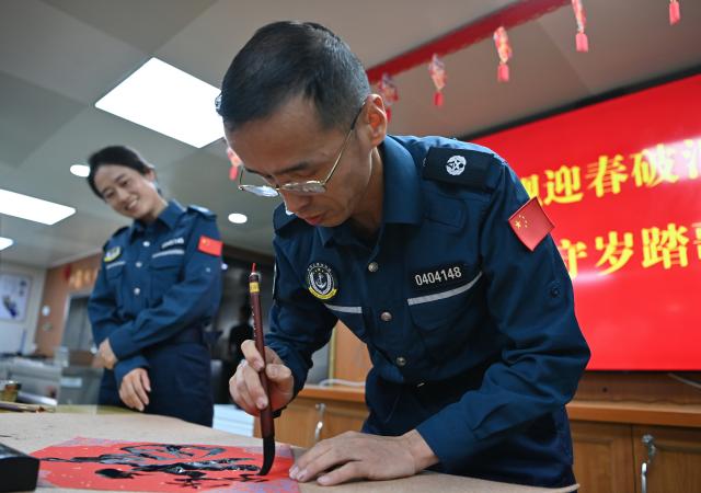 (260216) -- SOUTH CHINA SEA, Feb. 16, 2026 (Xinhua) -- A law enforcer writes Chinese character "Fu", which means good fortune, aboard the China Coast Guard (CCG) vessel Wanshan in the territorial waters of China's Huangyan Dao on Feb. 11, 2026.
  Law enforcers aboard the China Coast Guard (CCG) vessel Wanshan remain on duty during this year's Spring Festival, a most cherished moment for family reunions in China. (Photo by Zhai Yifan/Xinhua)