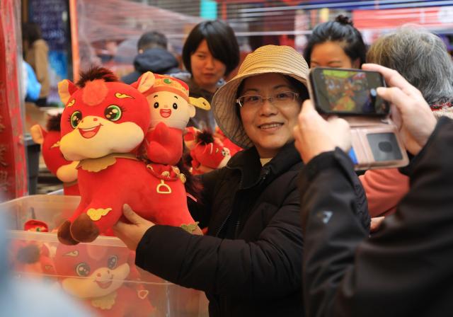 (260216) -- SAN FRANCISCO, Feb. 16, 2026 (Xinhua) -- A visitor poses for photos with a horse-themed toy at the Chinatown Flower Market Fair 2026 in San Francisco, the United States, Feb. 15, 2026.
  The 2-day event concluded here on Sunday. (Photo by Liu Yilin/Xinhua)