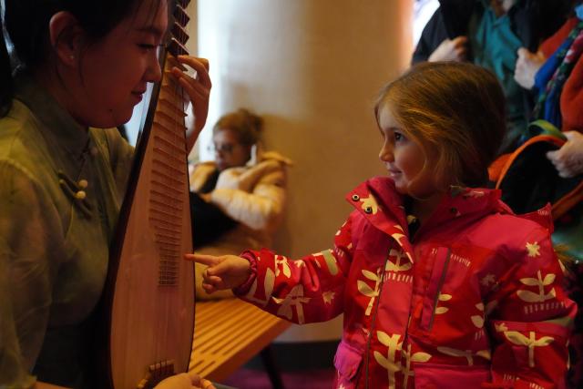 (260216) -- NEW YORK, Feb. 16, 2026 (Xinhua) -- A girl learns about pipa, a traditional Chinese instrument, before the 7th annual "The Sound of Spring" Chinese New Year Concert in New York, the United States, Feb. 15, 2026.
  TO GO WITH "Feature: Musicians in New York ring in Year of the Horse with themed concert" (Xinhua/Zhang Fengguo)