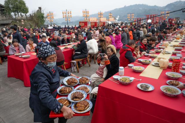 (260216) -- BEIJING, Feb. 16, 2026 (Xinhua) -- People enjoy a grand feast to mark the Chinese New Year's Eve in Songgai ancient town in southwest China's Chongqing, Feb. 16, 2026.
  Chinese New Year's Eve is the most significant moment of Spring Festival celebrations when families and friends sit around the table to share delicious food and personal stories, and stay up to welcome the New Year. (Xinhua/Chen Cheng)