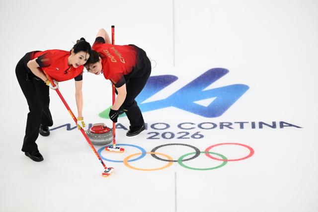 (260216) -- CORTINA D'AMPEZZO, Feb. 16, 2026 (Xinhua) -- Dong Ziqi (R) and Jiang Jiayi of China compete during the curling women round robin session 7 match between China and Canada at the 2026 Milan-Cortina Winter Olympics in Cortina, Italy, Feb. 16, 2026. (Xinhua/Lian Yi)