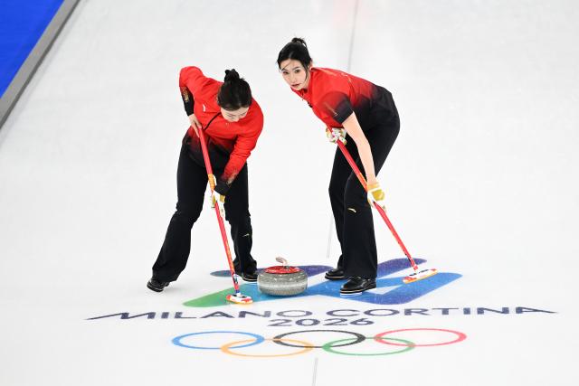 (260216) -- CORTINA D'AMPEZZO, Feb. 16, 2026 (Xinhua) -- Han Yu (L) and Jiang Jiayi of China compete during the curling women round robin session 7 match between China and Canada at the 2026 Milan-Cortina Winter Olympics in Cortina, Italy, Feb. 16, 2026. (Xinhua/Lian Yi)