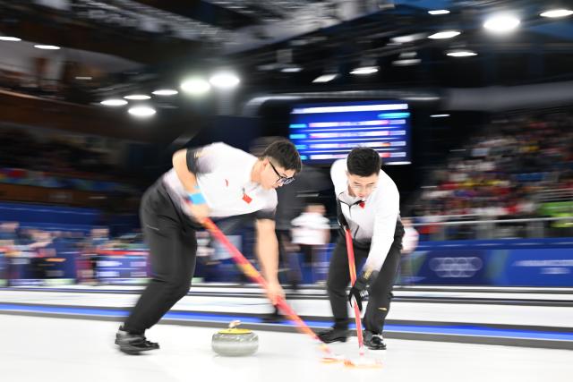 (260216) -- CORTINA D'AMPEZZO, Feb. 16, 2026 (Xinhua) -- Li Zhichao (L) and Xu Jingtao of China compete during the curling men's round robin session 8 match between China and Italy at the 2026 Milan-Cortina Winter Olympics in Cortina, Italy, Feb. 16, 2026. (Xinhua/Lian Yi)