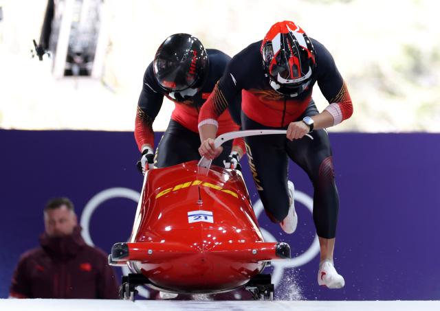 (260216) -- CORTINA D'AMPEZZO, Feb. 16, 2026 (Xinhua) -- Li Chunjian/Ye Jielong of China compete during the bobsleigh 2-man heat 1 at the 2026 Milan-Cortina Winter Olympics in Cortina, Italy, Feb. 15, 2026. (Xinhua/Ding Xu)