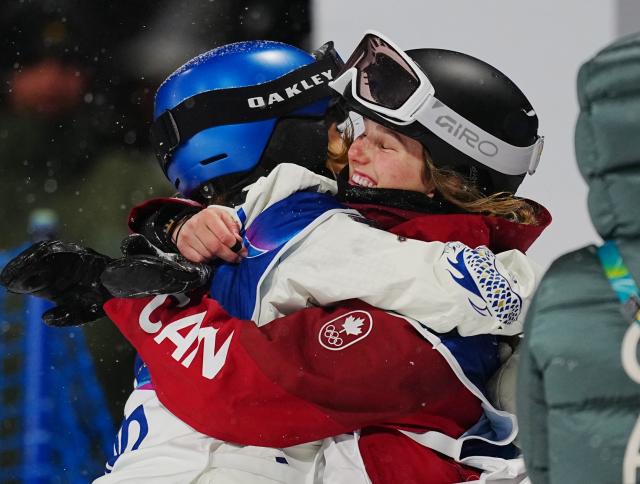(260216) -- LIVIGNO, Feb. 16, 2026 (Xinhua) -- Gu Ailing (L) of China hugs Megan Oldham of Canada after the freestyle skiing women's freeski big air final at the Milan-Cortina 2026 Olympic Winter Games in Livigno, Italy, Feb. 16, 2026. (Xinhua/Hu Chao)