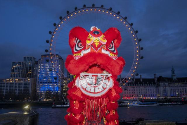 (260216) -- LONDON, Feb. 16, 2026 (Xinhua) -- Traditional Chinese lion dancers perform in front of the London Eye which is lit up in red to celebrate the Chinese New Year in London, Britain, Feb. 16, 2026. (Photo by Stephen Chung/Xinhua)