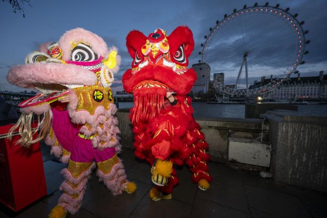 (260216) -- LONDON, Feb. 16, 2026 (Xinhua) -- Traditional Chinese lion dancers perform in front of the London Eye which is lit up in red to celebrate the Chinese New Year in London, Britain, Feb. 16, 2026. (Photo by Stephen Chung/Xinhua)