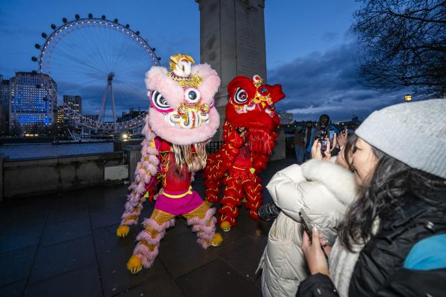 (260216) -- LONDON, Feb. 16, 2026 (Xinhua) -- Traditional Chinese lion dancers perform in front of the London Eye which is lit up in red to celebrate the Chinese New Year in London, Britain, Feb. 16, 2026. (Photo by Stephen Chung/Xinhua)