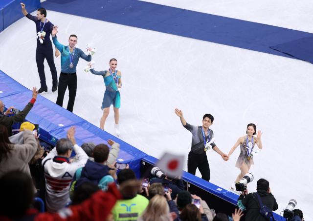 (260217) -- MILAN, Feb. 17, 2026 (Xinhua) -- Gold medalists Riku Miura(1st R)/Ryuichi Kihara(2nd R) of Japan, silver medalists Anastasiia Metelkina(3rd R)/Luka Berulava(4th R) of Georgia and bronze medalist Nikita Volodin of Germany wave to the spectators after the victory ceremony for Figure Skating Pair Skating at the Milan-Cortina 2026 Olympic Winter Games in Milan, Italy, Feb. 16, 2026. (Xinhua/Chen Yichen)