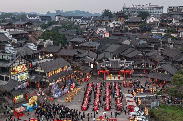 (260217) -- BEIJING, Feb. 17, 2026 (Xinhua) -- An aerial drone photo shows people enjoying a grand feast to mark the Chinese New Year's Eve in Songgai ancient town in southwest China's Chongqing, Feb. 16, 2026.
  Chinese New Year's Eve is the most significant moment of Spring Festival celebrations when families and friends sit around the table to share delicious food and personal stories, and stay up to welcome the New Year. (Xinhua/Chen Cheng)
