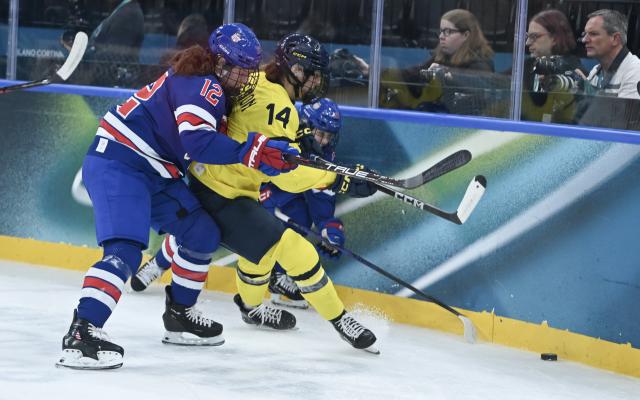 (260217) -- MILAN, Feb. 17, 2026 (Xinhua) -- Kelly Pannek (12) of the United States battles for the puck with Sweden's Ida Karlsson (14) during the Play-offs Semifinals match between the United States and Sweden of Ice hockey Women at the Milan-Cortina 2026 Olympic Winter Games in Milan, Italy, Feb. 16, 2026. (Xinhua/Zhang Haofu)