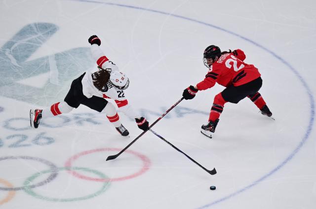 (260217) -- MILAN, Feb. 17, 2026 (Xinhua) -- Switzerland's Sinja Leemann(22) battles for the puck with Canada's Erin Ambrose during the Play-offs Semifinals match between Canada and Switzerland of Ice hockey Women at the Milan-Cortina 2026 Olympic Winter Games in Milan, Italy, Feb. 16, 2026. (Xinhua/Tao Xiyi)
