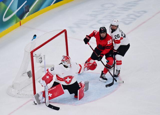 (260217) -- MILAN, Feb. 17, 2026 (Xinhua) -- Switzerland's goalkeeper Andrea Braendli (20) reaches for the puck along with Naemi Herzig (26) and Canada's Sarah Nurse(20) during the Play-offs Semifinals match between Canada and Switzerland of Ice hockey Women at the Milan-Cortina 2026 Olympic Winter Games in Milan, Italy, Feb. 16, 2026. (Xinhua/Tao Xiyi)