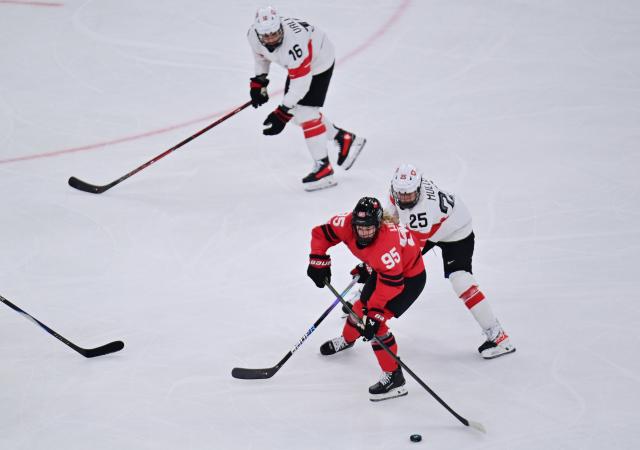 (260217) -- MILAN, Feb. 17, 2026 (Xinhua) -- Switzerland's Alina Muller(25) battles for the puck with Canada's Daryl Watts during the Play-offs Semifinals match between Canada and Switzerland of Ice hockey Women at the Milan-Cortina 2026 Olympic Winter Games in Milan, Italy, Feb. 16, 2026. (Xinhua/Tao Xiyi)