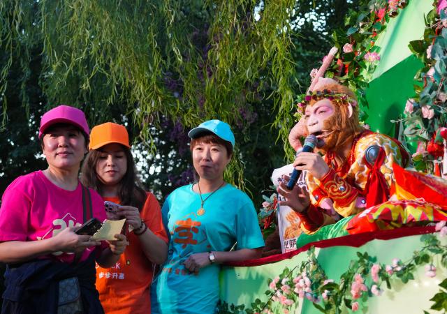 (260217) -- CHANGCHUN, Feb. 17, 2026 (Xinhua) -- Wang Qingfeng acting as the "Xuebing Monkey", or rice-cracker monkey, interacts with tourists at the Changchun Zoological and Botanical Park in Changchun, northeast China's Jilin Province, Sept. 18, 2025. TO GO WITH "Profile: A Monkey King and a region in transition" (Xinhua)