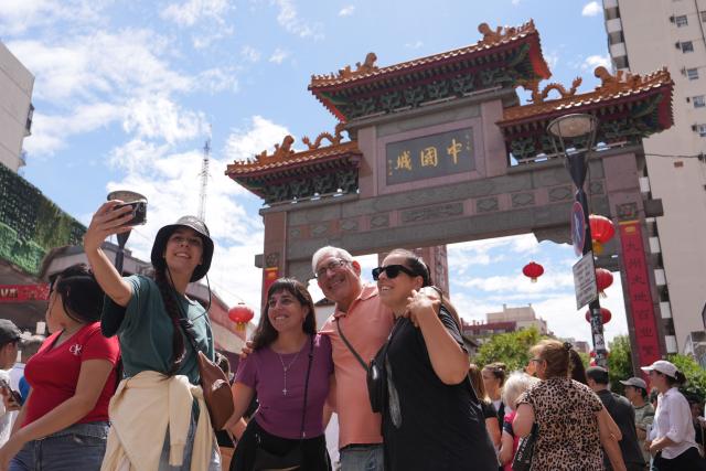 (260217) -- BUENOS AIRES, Feb. 17, 2026 (Xinhua) -- People take selfies in the Chinatown in Buenos Aires, capital of Argentina, Feb. 16, 2026. The event kicked off on Monday, featuring dragon and lion dances, traditional Chinese dance performances, as well as cultural experience activities such as martial arts and calligraphy. (Xinhua/Zhang Duo)