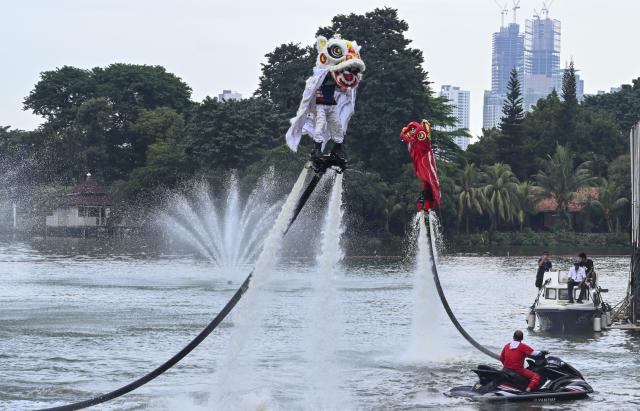 (260217) -- JAKARTA, Feb. 17, 2026 (Xinhua) -- Actors perform lion dance with water-powered jetpack flying machines to celebrate the Chinese New Year in Jakarta, Indonesia, Feb. 16, 2026. (Xinhua/Zulkarnain)